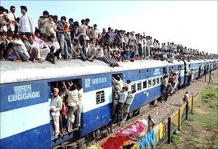 Devotees travel on a crowded passenger train.