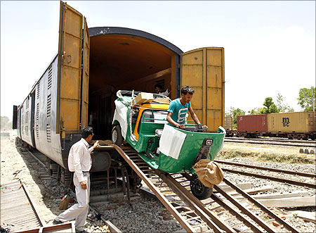 A new auto rickshaw is unloaded from a goods train at a storage facility at Sanand railway station.