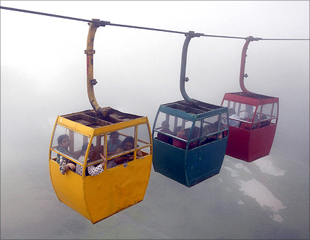 Tourists enjoy their ropeway ride amid a mist of monsoon clouds at the Saputara hill station near Ahmedabad.