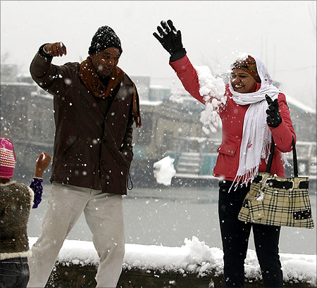 A Indian tourist couple playfully tosses snow at each other during the winter season's first snowfall in Srinagar.