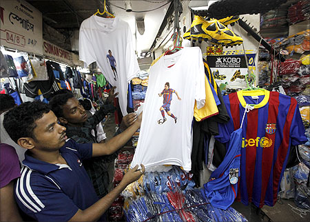 Soccer fans shop for t-shirts and jerseys featuring Argentinan and Venezuelan soccer players at a sports goods market in Kolkata.