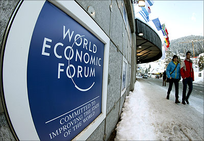 People walk past the logo of the World Economic Forum in front of the congress centre in Davos.