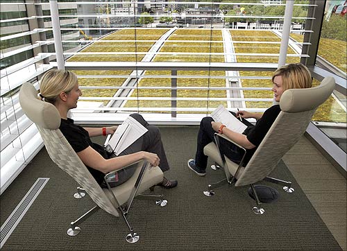 New-media employees Jennifer Hauseman and Tyler LePar have a conference on what staff like to call the diving platform on the sixth floor.