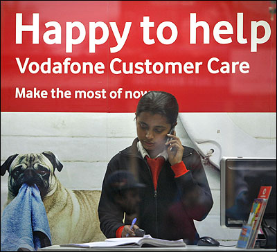 An employee talks on mobile phone inside a Vodafone store in Agartala.