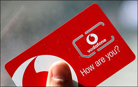 A woman holds a Vodafone sim card in central London on May 30, 2006.