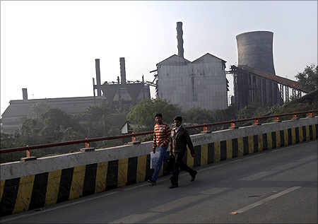 People walk past a closed sugar mill in Patna.