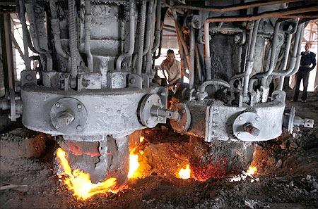 An employee works inside a steel factory.