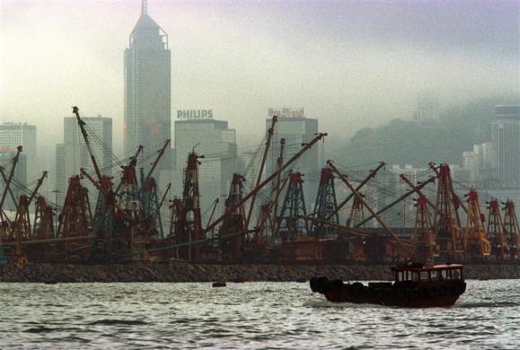 A lone sampan floats by barges inside a typhoon shelter in Victoria harbour.