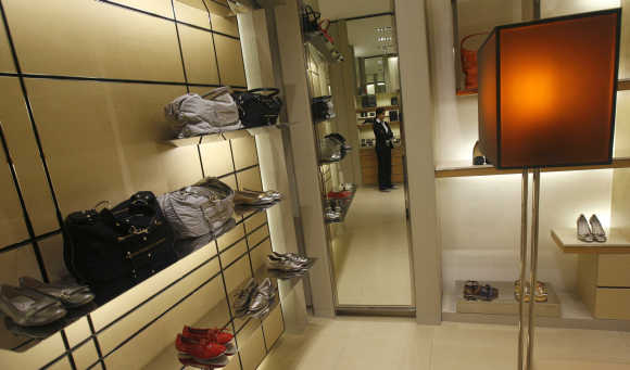 An employee is reflected in a mirror as she waits for customers inside a showroom at the Emporio mall in New Delhi.