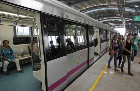 Commuters disembark from a Metro at an elevated station in the Indira Nagar area of Bangalore.
