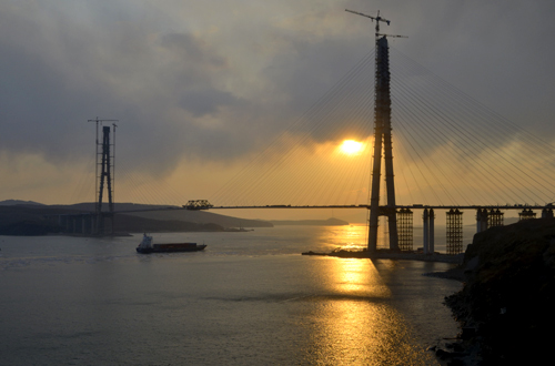 The sun sets behind a bridge under construction linking Russky Island (R) to the mainland, near Russia's far Eastern port of Vladivostok.