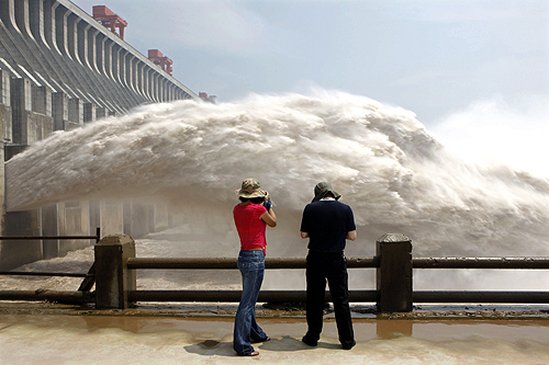 Journalists take pictures as the Three Gorges Dam discharges water to lower the level in its reservoir in Yichang, Hubei province.