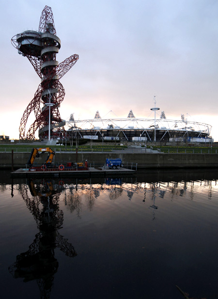 Olympic stadium and Anish Kapoor's ArcelorMittal Orbit tower are reflected in a canal in Stratford, east London.