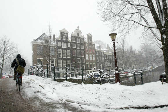A cyclist makes his way over a snow covered bridge in the Dutch capital of Amsterdam.