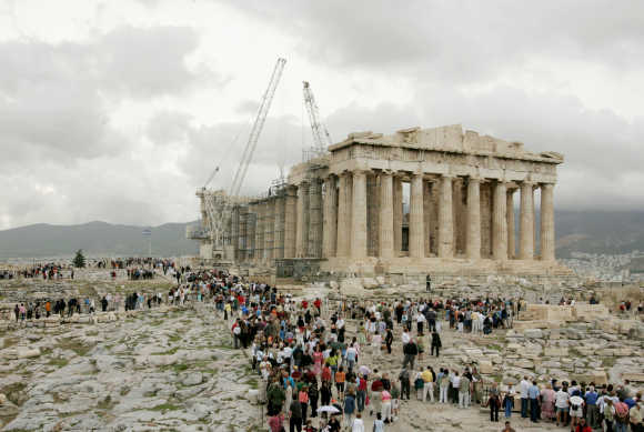 Tourists visit the temple of the Parthenon at the Acropolis hill in Athens.