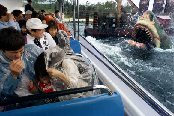 Japanese guests react as 'Jaws' emerges out of the water in a ride attraction at Universal Studios in Osaka, Japan.