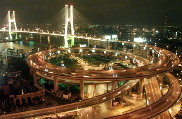 Vehicles pass through teh brightly-lit Nanpu Bridge in Shanghai.
