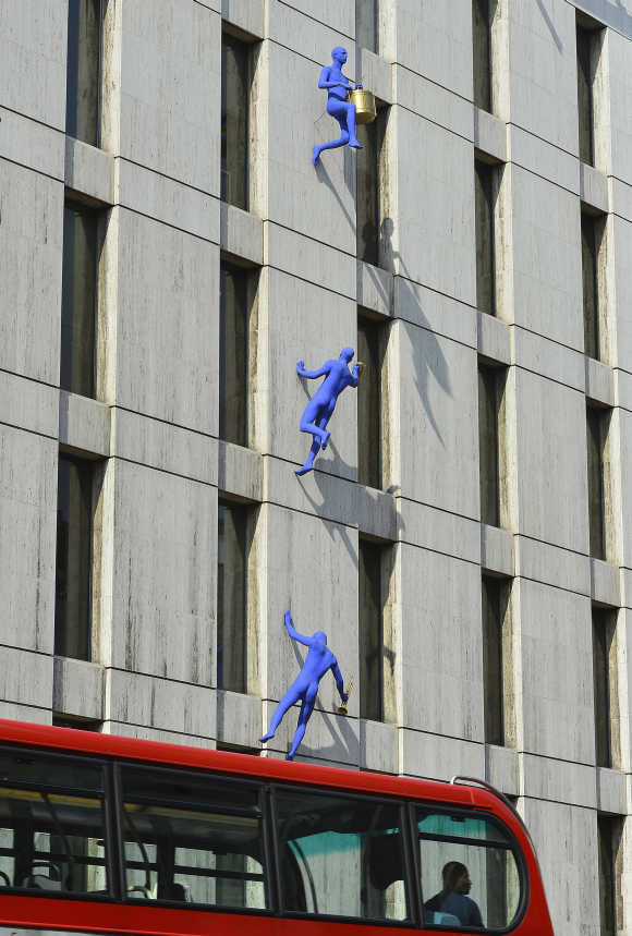 Sculptures entitled Blue Men are seen on the wall of a building on Borough High Street in south London.