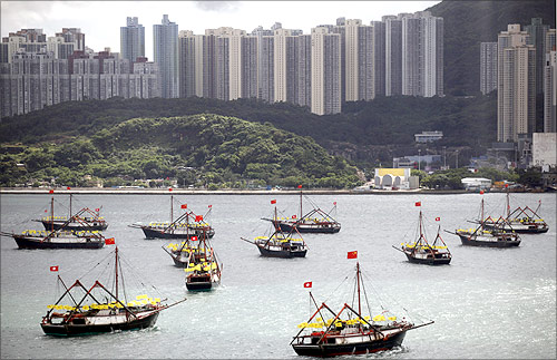 Fishing vessels bearing both Chinese and Hong Kong flags sail in Hong Kong's Victoria harbour.