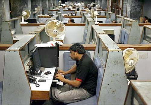 A stockbroker sits in his booth as he follows the latest share prices during a trading session inside the trading hall of the Karachi Stock Exchange.