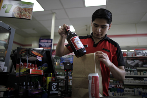 Abel Santiago, 21, serves a customer at a 7-Eleven convenience store in Santa Monica, California.