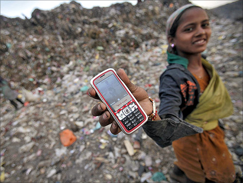 A ragpicker holds her mobile phone to show a picture she took at a dump yard on World Environment Day in New Delhi.