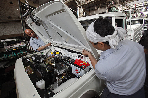 Employees affix a bonnet as they work on assembling a Mahindra Bolero vehicle at the company's manufacturing plant on the outskirts of Mumbai.