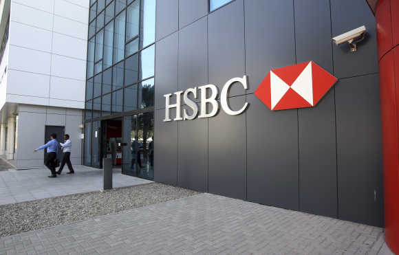 People exit an HSBC branch at Dubai Internet City in Dubai.