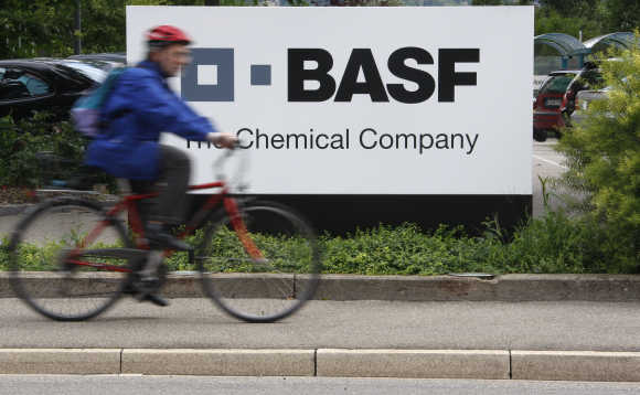 A cyclist rides his bike past the BASF plant in Schweizerhalle near Basel, Switzerland.