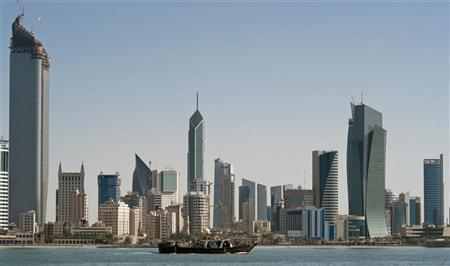 A fishing boat passes in front of the Kuwait City skyline
