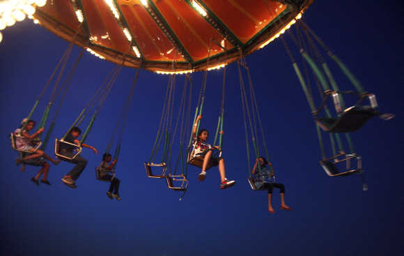 Children enjoy a ride at an amusement park in Noida.