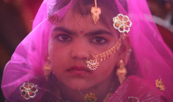 A veiled girl from the Saraniya community waits for her engagement ceremony to start at Vadia village in Gujarat.