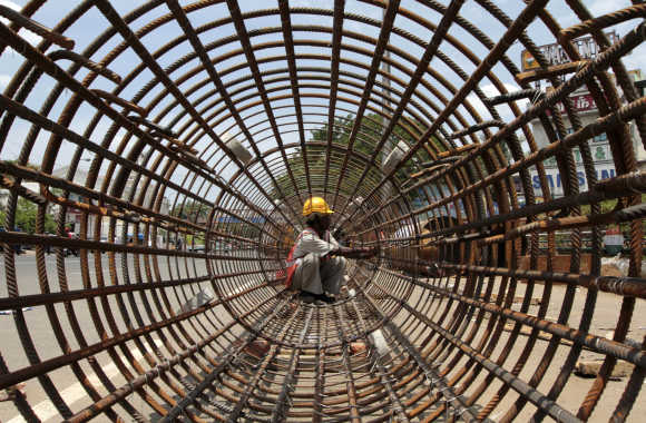 A worker tightens steel rebars at a construction site of a metro station in Chennai.