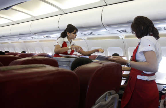 Cabin attendants serve snacks on a flight after takeoff from Mumbai's domestic airport.