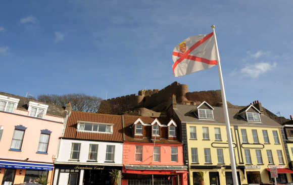 The Mont Orgueil Castle is seen behind an island flag at Gorey Harbour in Jersey.