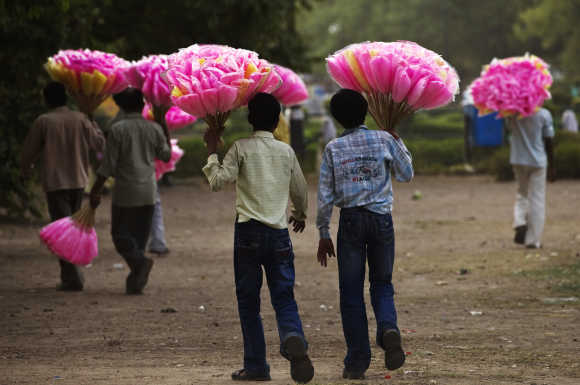 Vendors hold bags of cotton candy for sale as they look for customers in New Delhi.