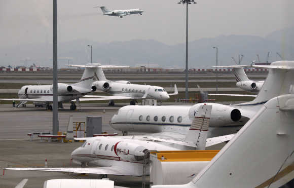 A business jet takes off as others are parked at the Hong Kong Airport.