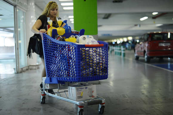 A woman pushes a shopping trolley in the car park of a supermarket near Bilbao.