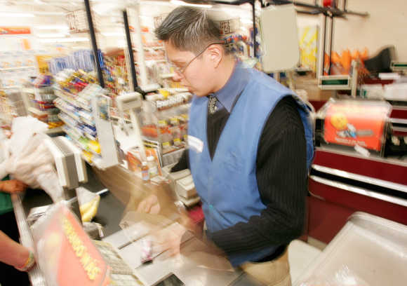 A cashier is a blur of activity as he speeds products past the electric point of sale bar code sensor in Mexico City.