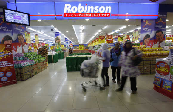 People shop at a Robinson supermarket outlet in Cileduk of South Jakarta.