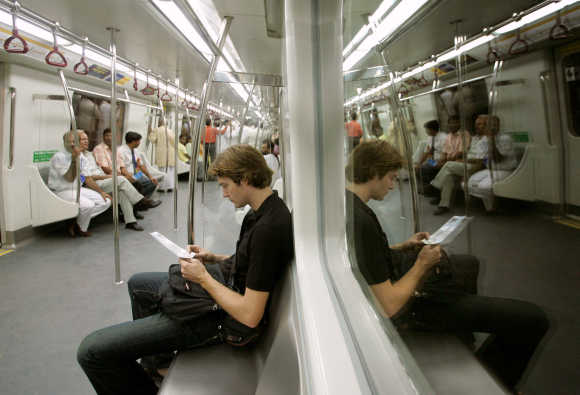Passengers sit inside carriage of Delhi Metro rail in New Delhi.