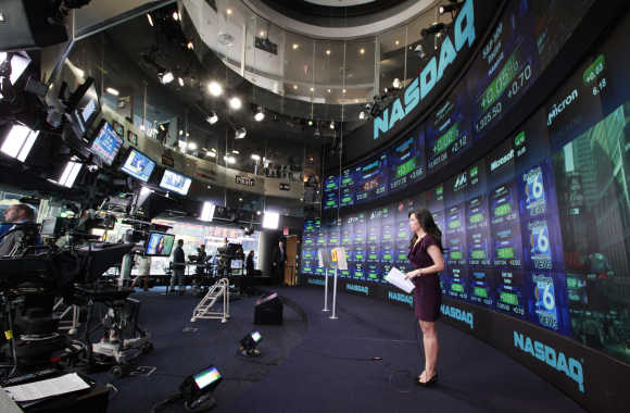 A television reporter broadcasts from the Nasdaq Marketsite in New York