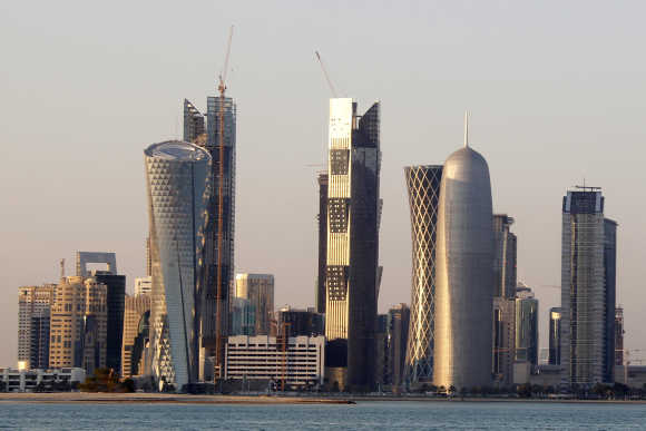 Sun reflects off the glass and steel buildings on the Doha skyline.