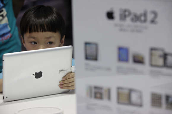 A boy views an iPad 2 tablet computer at an Apple dealership in Wuhan, Hubei province.