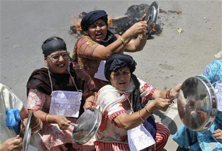 Demonstrators bang kitchen utensils and shout slogans during a protest against the price hike in petrol.