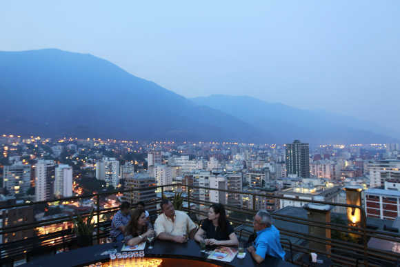 People have a drink at 360, a three-tiered rooftop bar, in capital Caracas.