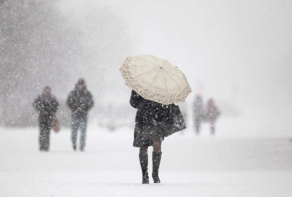 People walk during heavy snowfall in central Minsk.
