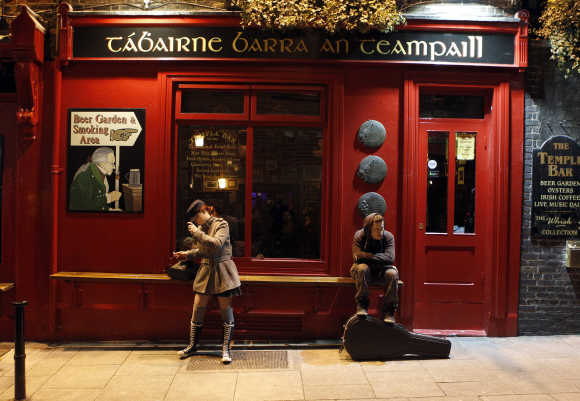 People hang around outside a bar in the Temple Bar area of central Dublin.