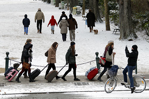 Tourists pull their bags over freshly-fallen snow in Paris as sub-freezing winter temperatures continue in Europe.