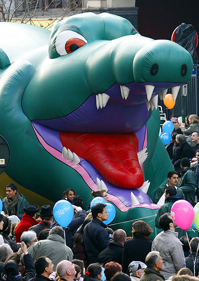 A giant balloon depicting a dragon floats above participants of Balloon Day Parade in central Brussels.